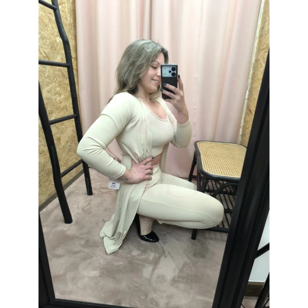Conjunto feminino de três peças em bege, composto por top cropped, calça ajustada e casaco longo.