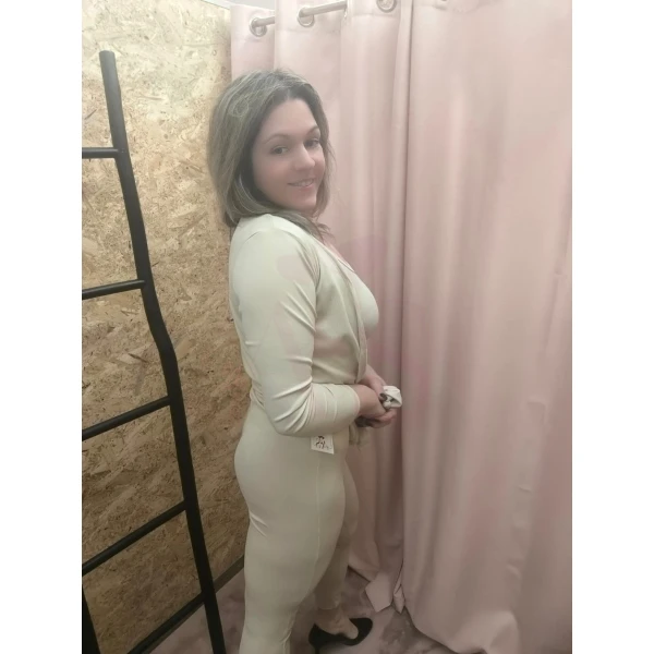 Conjunto feminino de três peças em bege, composto por top cropped, calça ajustada e casaco longo.