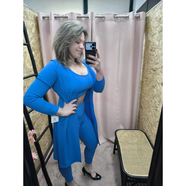conjunto feminino de três peças em azulão, composto por top cropped, calça ajustada e casaco longo.