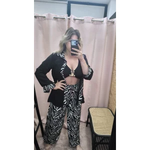 Conjunto Wild Elegance composto por camisa preta com detalhes zebra e calças animal print.