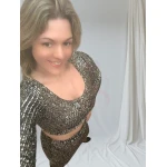 Mulher vestindo conjunto brilhante cinzento, composto por top cropped e saia midi.