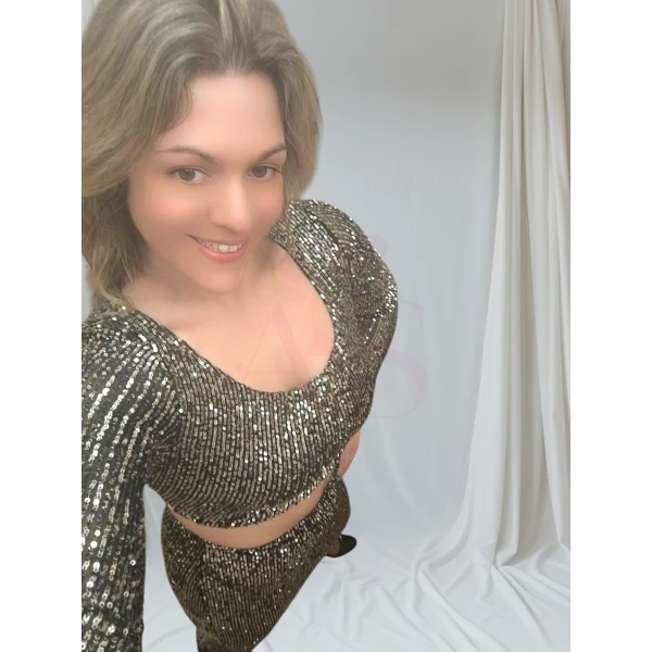 Mulher vestindo conjunto brilhante cinzento, composto por top cropped e saia midi.