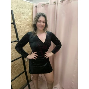 "Vestido Glow Elegance curto de manga comprida, em tecido brilhante, disponível em preto, ideal para ocasiões especiais e eventos noturnos."