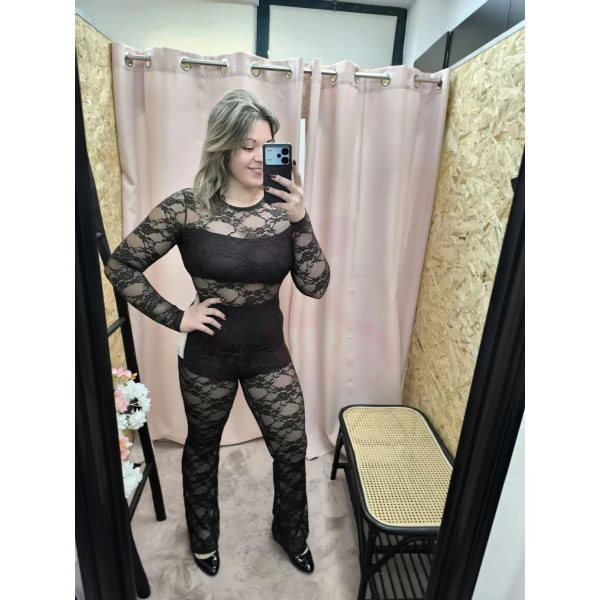 Mulher usando o Macacão Sensuelle longo em renda floral, com forro curto e transparência elegante.
