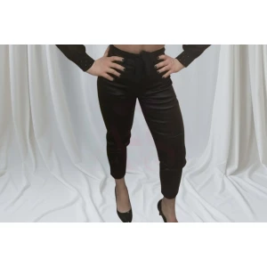 Calça feminina cintura alta com botão frontal e ajuste elegante.