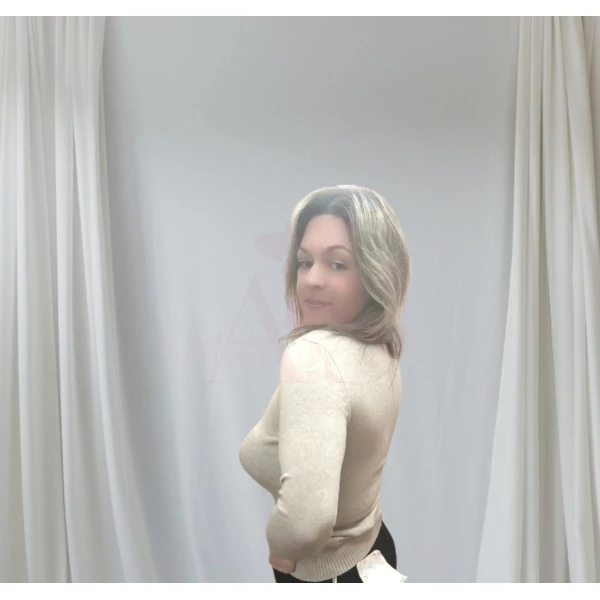 Mulher vestindo camisola feminina com corações, disponível em branco com corações vermelhos e bege com corações dourados.