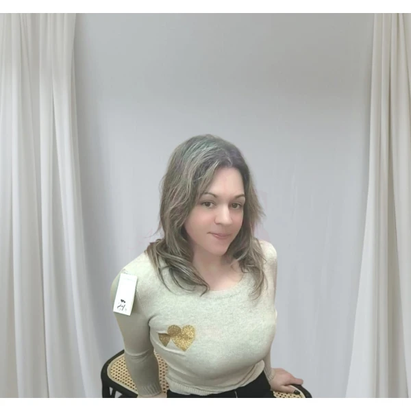 Mulher vestindo camisola feminina com corações, disponível em branco com corações vermelhos e bege com corações dourados.