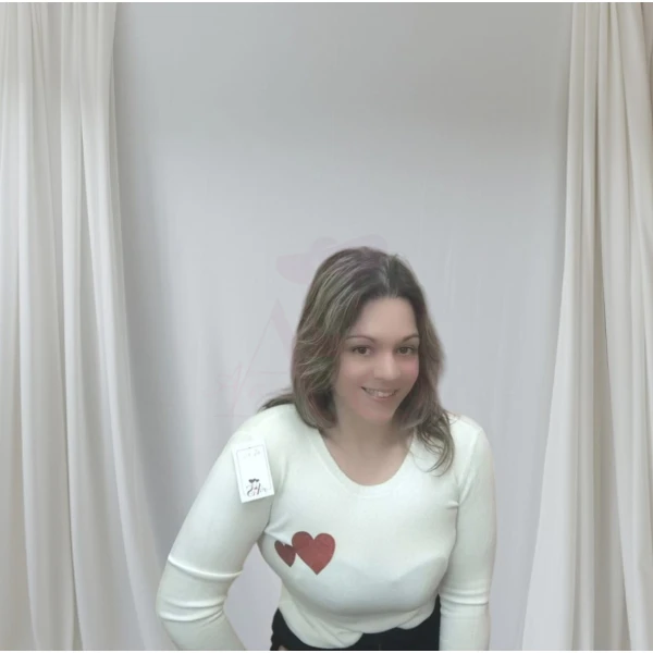 Mulher vestindo camisola feminina com corações, disponível em branco com corações vermelhos e bege com corações dourados.