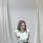 Mulher vestindo camisola feminina com corações, disponível em branco com corações vermelhos e bege com corações dourados.
