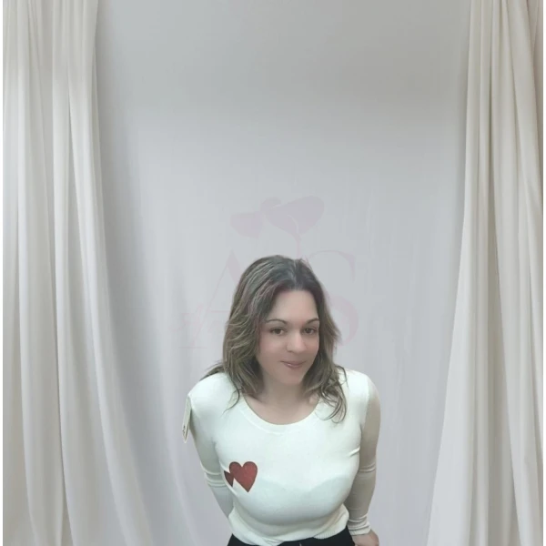 Mulher vestindo camisola feminina com corações, disponível em branco com corações vermelhos e bege com corações dourados.