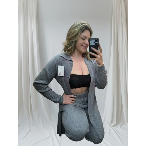 Conjunto de malha elegante em tom neutro, com casaco de botões e calças fluídas.