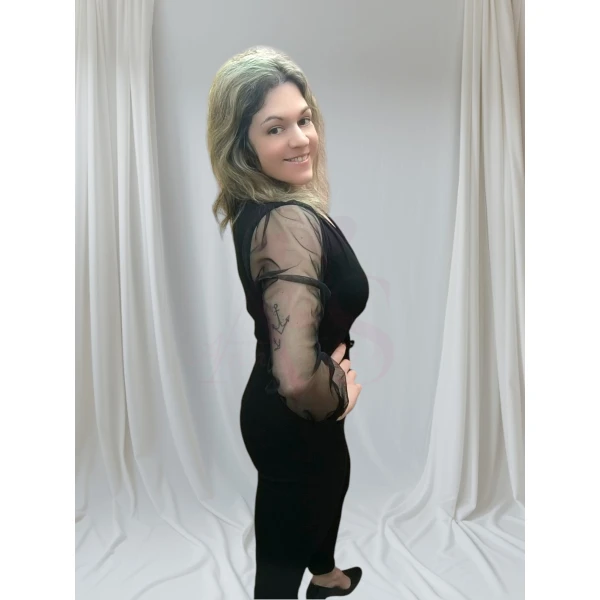 macacão elegância absoluta preto com mangas em tule transparente, posando para realçar o design elegante.