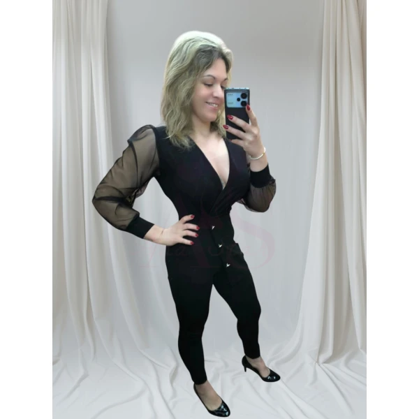 macacão elegância absoluta preto com mangas em tule transparente, posando para realçar o design elegante.