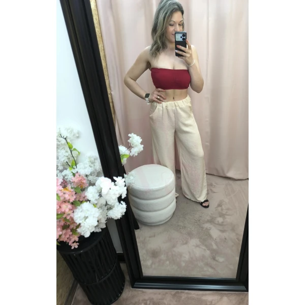 O Conjunto Bege Leveza Urbana é composto por colete sem mangas e calça com elástico e bolsos, em tecido fino e leve. Ideal para um look descontraído e elegante nos dias quentes.