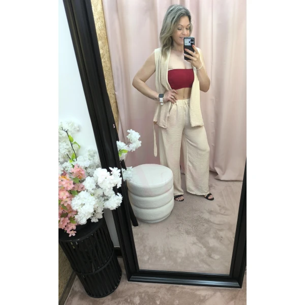 O Conjunto Bege Leveza Urbana é composto por colete sem mangas e calça com elástico e bolsos, em tecido fino e leve. Ideal para um look descontraído e elegante nos dias quentes.