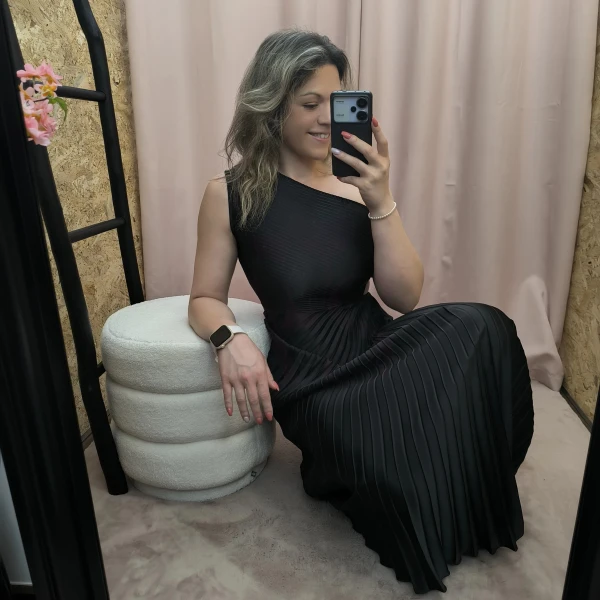 Mulher a usar o vestido Dress Divine Pleats em rosa fúcsia e preto com corte assimétrico e plissado.