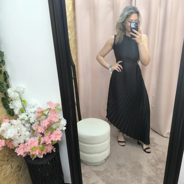 Mulher a usar o vestido Dress Divine Pleats em rosa fúcsia e preto com corte assimétrico e plissado.