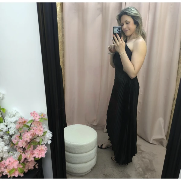 Mulher a usar o vestido Dress Divine Pleats em rosa fúcsia e preto com corte assimétrico e plissado.