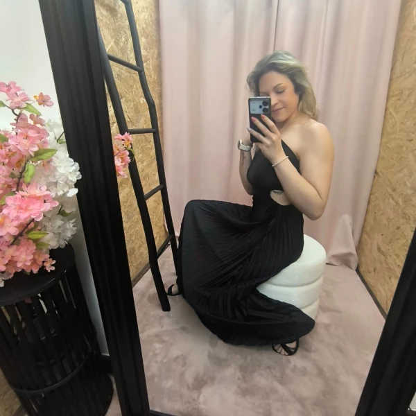 Mulher a usar o vestido Dress Divine Pleats em rosa fúcsia e preto com corte assimétrico e plissado.