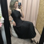 Mulher a usar o vestido Dress Divine Pleats em rosa fúcsia e preto com corte assimétrico e plissado.