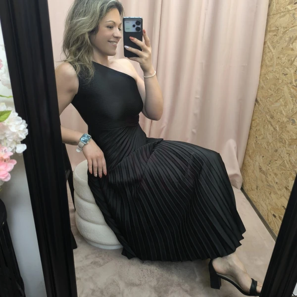 Mulher a usar o vestido Dress Divine Pleats em rosa fúcsia e preto com corte assimétrico e plissado.