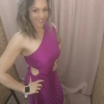 Mulher a usar o vestido Dress Divine Pleats em rosa fúcsia e preto com corte assimétrico e plissado.