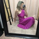 Mulher a usar o vestido Dress Divine Pleats em rosa fúcsia e preto com corte assimétrico e plissado.