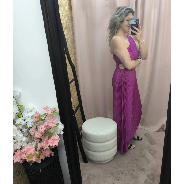 Mulher a usar o vestido Dress Divine Pleats em rosa fúcsia e preto com corte assimétrico e plissado.