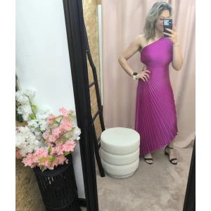 Mulher a usar o vestido Dress Divine Pleats em rosa fúcsia e preto com corte assimétrico e plissado.