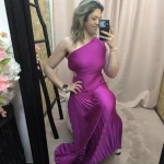 Mulher a usar o vestido Dress Divine Pleats em rosa fúcsia e preto com corte assimétrico e plissado.