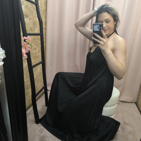 O Vestido Aura Plissada em azul e preto, com detalhe plissado e costas abertas.