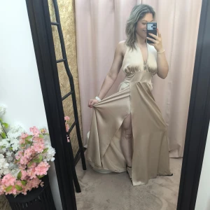 Robe Satiné Divine Évasion em cetim nude com corte fluido e costas abertas.