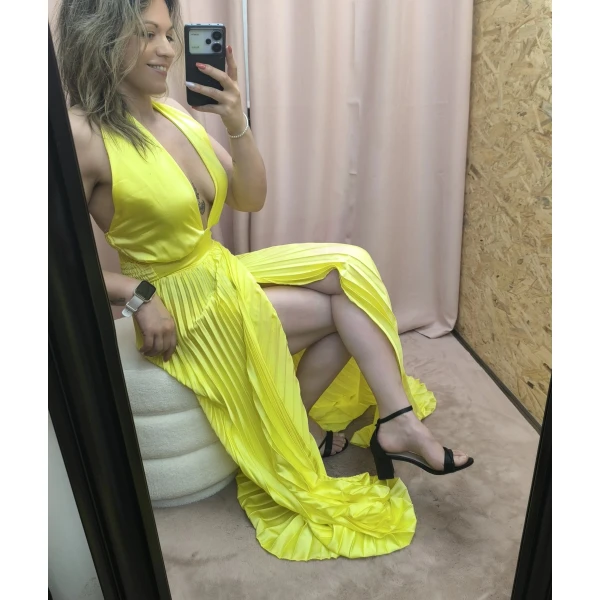 Vestido amarelo plissado com brilho, decote profundo e corte ousado