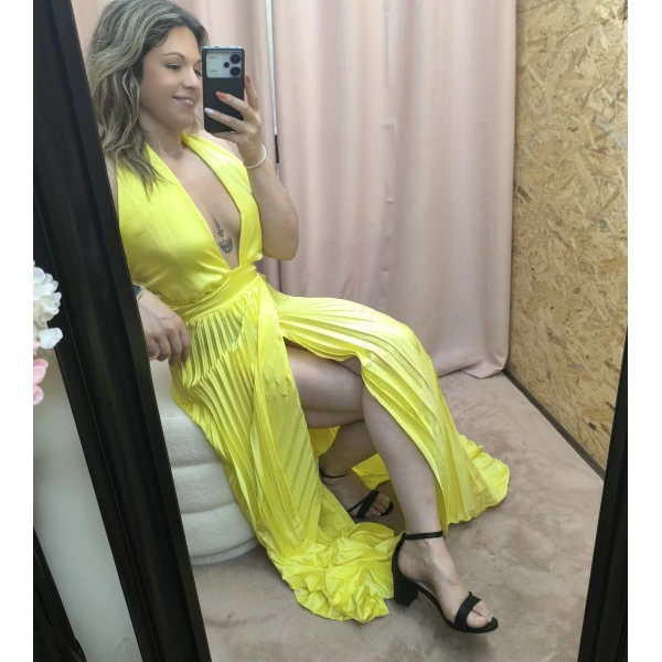 Vestido amarelo plissado com brilho, decote profundo e corte ousado
