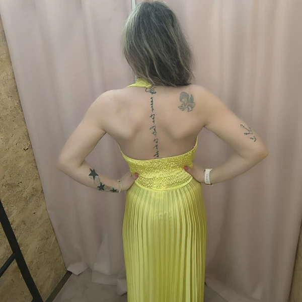 Vestido amarelo plissado com brilho, decote profundo e corte ousado