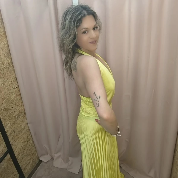 Vestido amarelo plissado com brilho, decote profundo e corte ousado