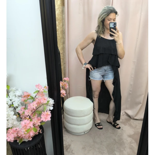 Mulher a usar o top fluide à volants em diferentes cores e posições.
