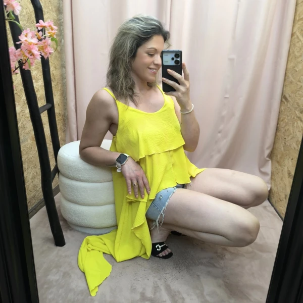 Mulher a usar o top fluide à volants em diferentes cores e posições.