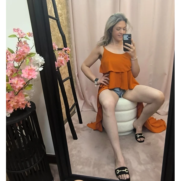 Mulher a usar o top fluide à volants em diferentes cores e posições.