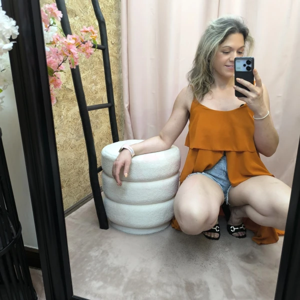 Mulher a usar o top fluide à volants em diferentes cores e posições.