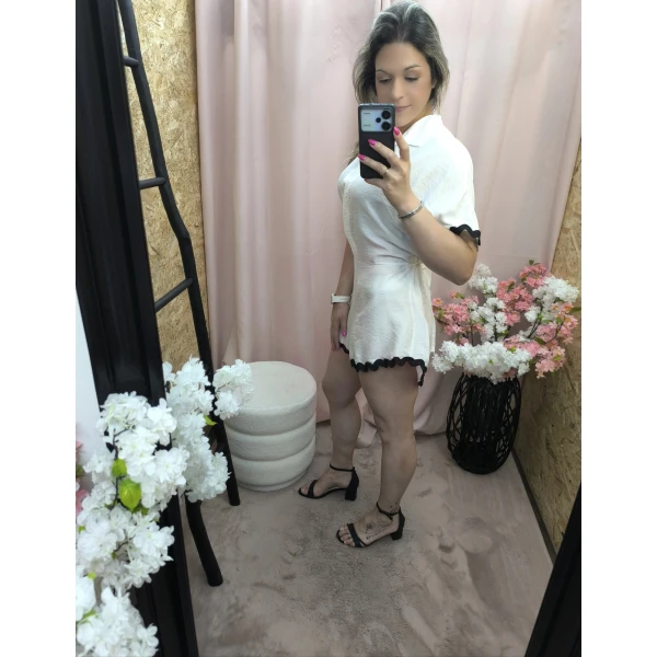 Macacão Brisa de Verão em branco com detalhes pretos.