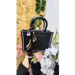 Bolsa preta feminina sofisticada com lenço decorativo e alça extra geométrica.